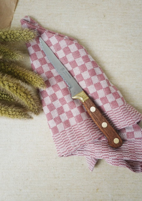 A La Formi knife on top of a table napkin